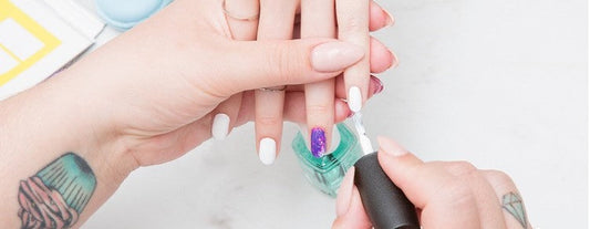 Prothésiste ongulaire entrain de poser du vernis sur une cliente